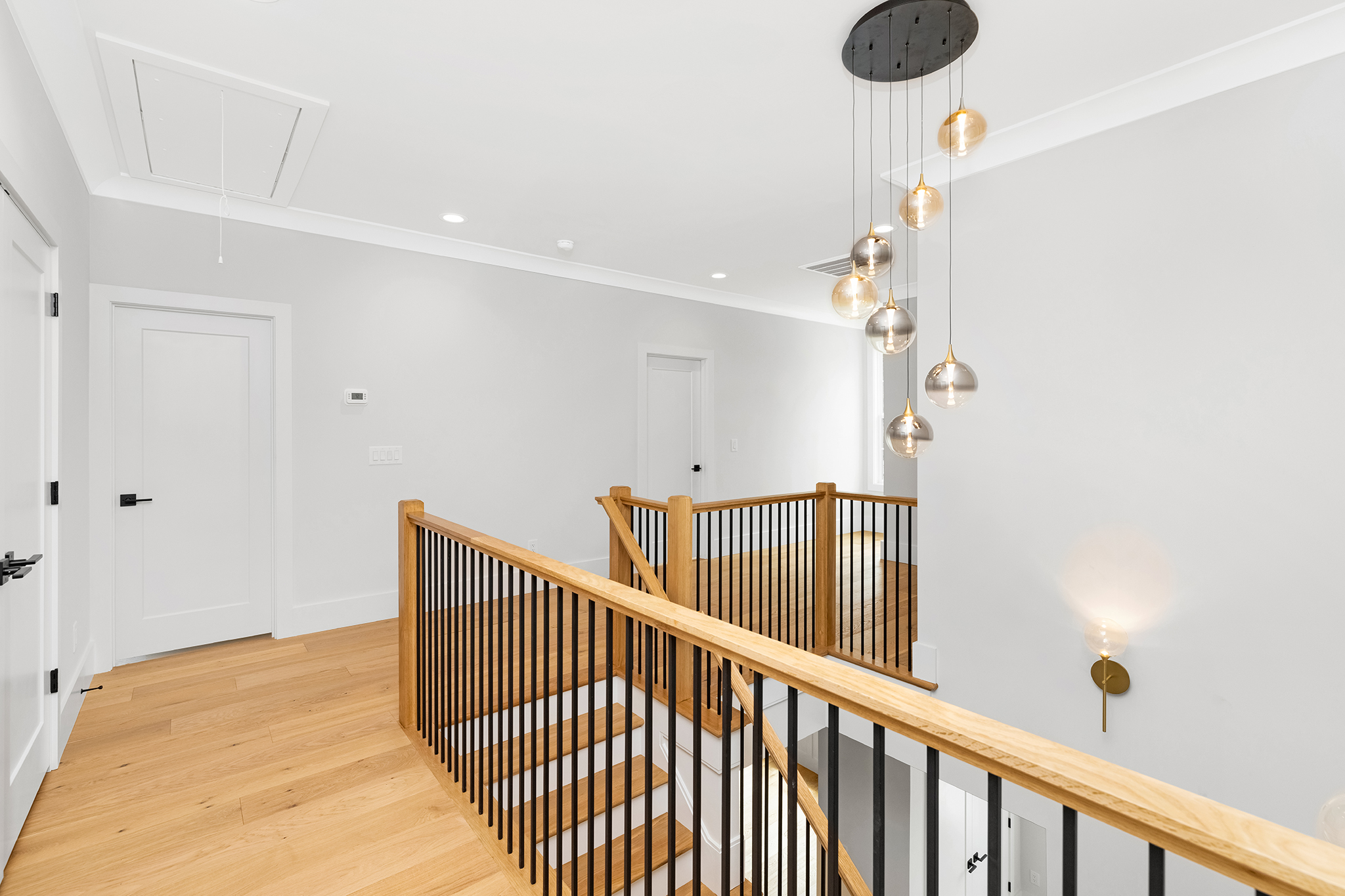Upstairs landing with a wood and iron stair railing