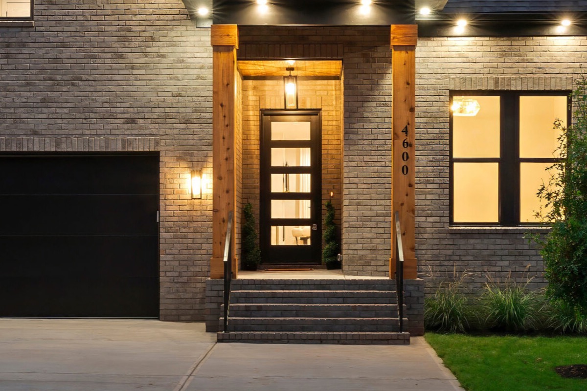 Northway home brick exterior at night with string lights along the roofline and an illuminated entry