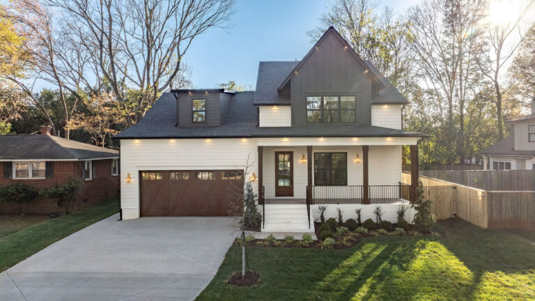 Two-story white and dark exterior with an attached garage
