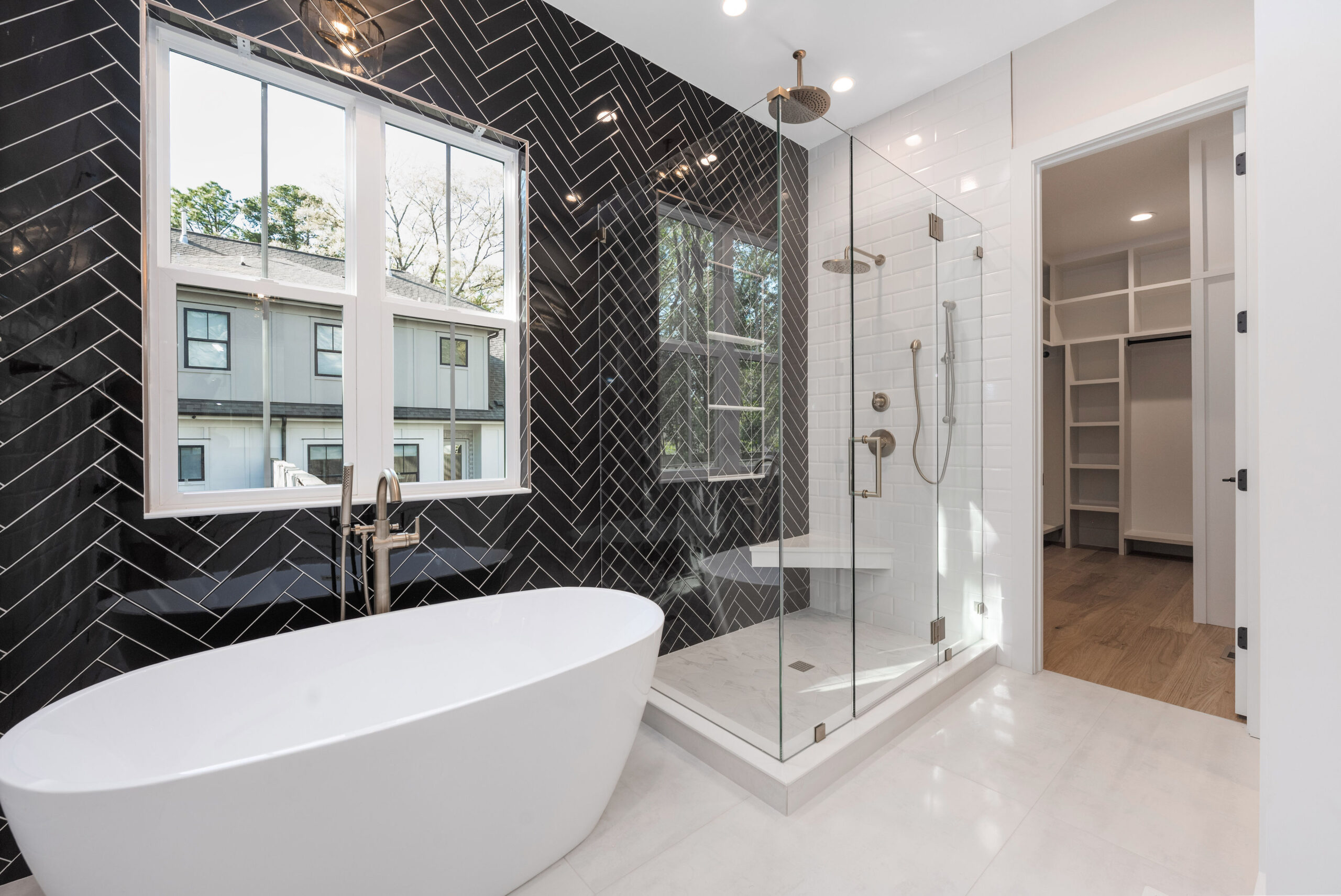 Primary bathroom with a freestanding tub and herringbone tile