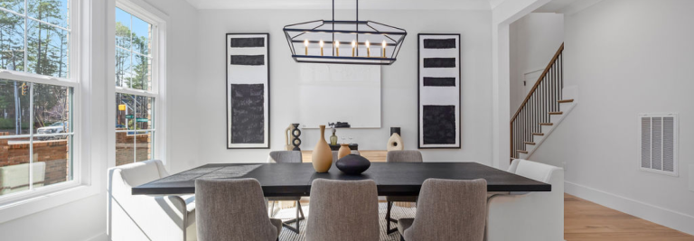Staged dining room with a dark wood table, upholstered chairs, and a black metal chandelier in a Northway Homes interior